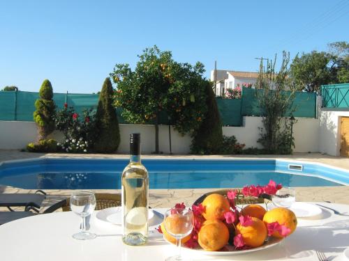 Villa Pergia Latchi في بوليس خريسوخوس: طاولة مع زجاجة من النبيذ وصحن من الفاكهة