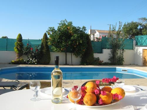 a table with a bottle of wine and a plate of fruit at Villa Pergia Latchi in Polis Chrysochous