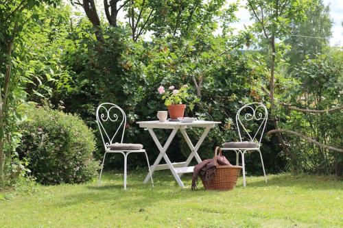 a table and two chairs in a yard with a table and a basket at Familjevänligt hus med stor trädgård in Vallsta