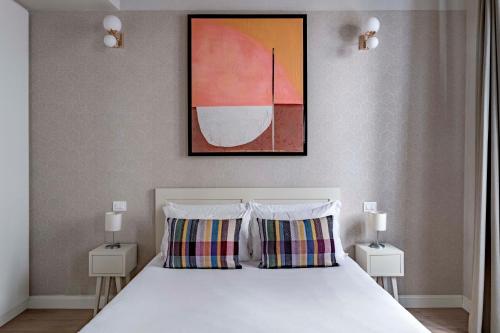 um quarto com uma cama com duas almofadas e um quadro em numa I Fiore Apartments em Florença