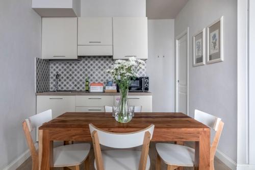a kitchen with a wooden table and white cabinets at Numa Florence Fiore in Florence