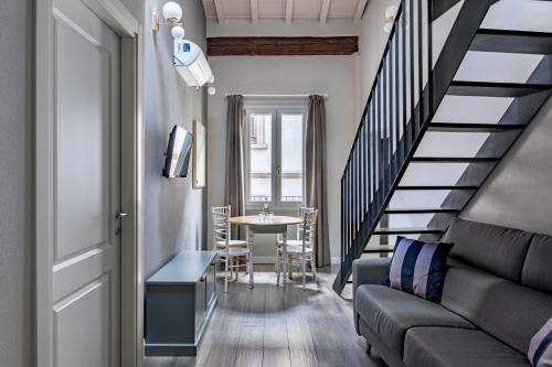 a living room with a staircase and a table with chairs at Numa Florence Fiore in Florence