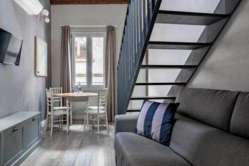 uma sala de estar com uma escada com um sofá e uma mesa em numa I Fiore Apartments em Florença