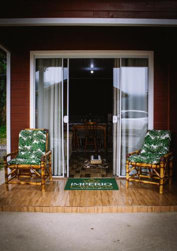 two chairs sitting on a porch with a table at Império Cabanas in Urubici