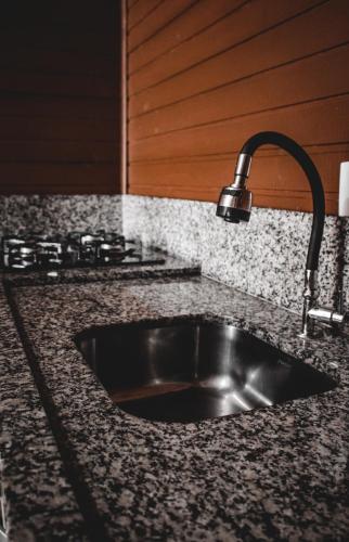 a kitchen sink with a faucet on a counter at Império Cabanas in Urubici
