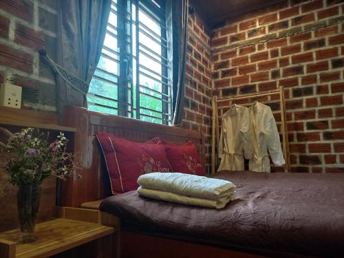 Habitación de ladrillo con cama y ventana en Retreat Home Bản Dọi Mộc Châu en Mộc Châu
