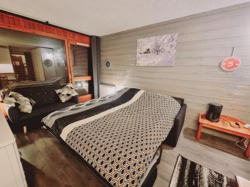 a bedroom with a large bed and a couch at LE PLEIN SUD in Les Deux Alpes