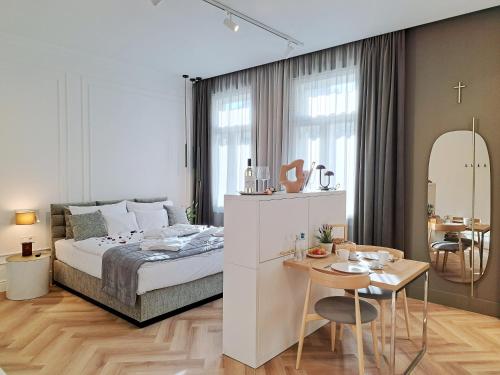 1 dormitorio con 1 cama, zona de comedor y mesa en Hotel Domus Collis en Győr
