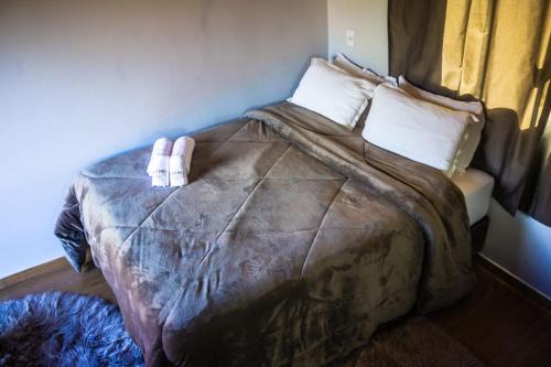 a bedroom with a large bed with two pillows at Império Cabanas in Urubici