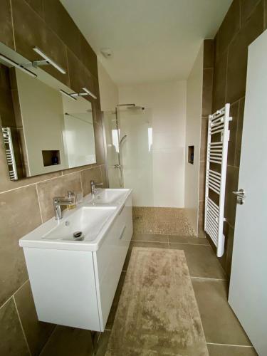 une salle de bain avec un lavabo blanc et un miroir dans l'établissement Villa avec piscine chauffée idéalement située, à Mimizan