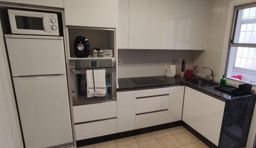 uma cozinha com um frigorífico branco e um micro-ondas em The Urban Flat Vigo em Vigo