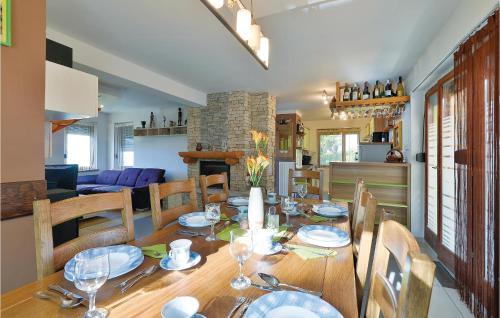 a dining room with a wooden table with chairs and a room with a fireplace at 3 Bedroom Pet Friendly Home In Ludbreg in Ludbreg