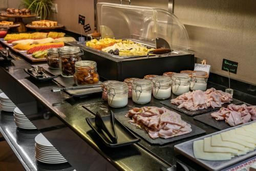 a buffet line with meat and other foods on plates at Vincci Albayzin in Granada