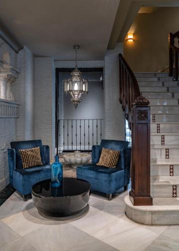 a living room with blue furniture and a chandelier at Vincci Albayzin in Granada