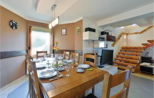 a dining room with a table and a television at 3 Bedroom Pet Friendly Home In Ludbreg in Ludbreg
