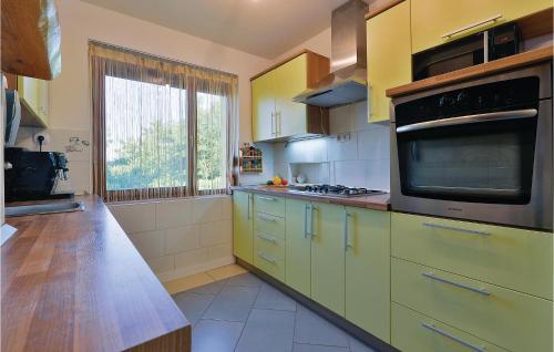 a kitchen with yellow cabinets and a large window at 3 Bedroom Pet Friendly Home In Ludbreg in Ludbreg