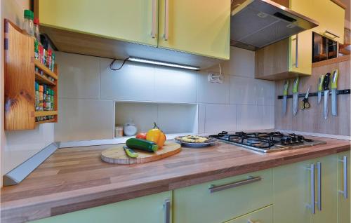 a kitchen with a cutting board with fruits and vegetables on a counter at 3 Bedroom Pet Friendly Home In Ludbreg in Ludbreg