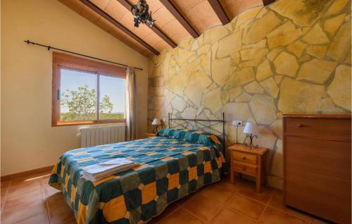 1 dormitorio con cama y pared de piedra en Beautiful Home In Caravaca De La Cruz With Outdoor Swimming Pool And 3 Bedrooms en Caravaca de la Cruz