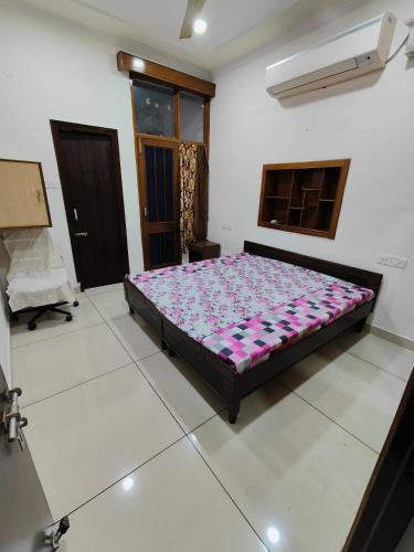 ein Schlafzimmer mit einem Bett in der Mitte eines Zimmers in der Unterkunft Chandigarh home in Chandīgarh