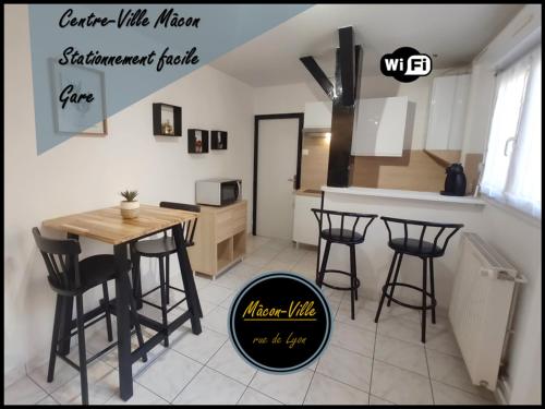 cocina con mesa y sillas en una habitación en Mâcon Centre ville-gare-wifi-cosy-parking public à proximité en Mâcon