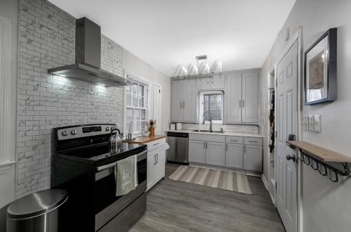 a kitchen with white cabinets and a black stove top oven at Shaker Heights- WiFi, 1st Floor in Shaker Heights