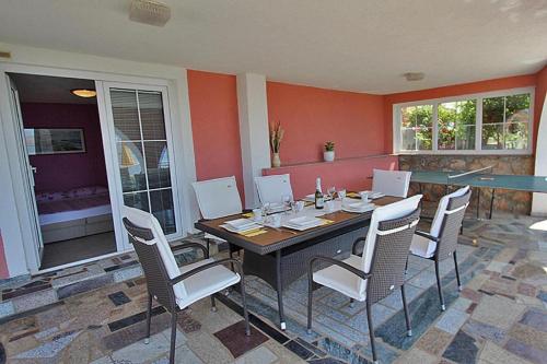 a dining room with a table and white chairs at Villa Lilly 2 in Cesarica