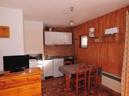 a kitchen with a table and a kitchen with white appliances at Studio Valloire, 1 pièce, 4 personnes - FR-1-263-44 in Valloire