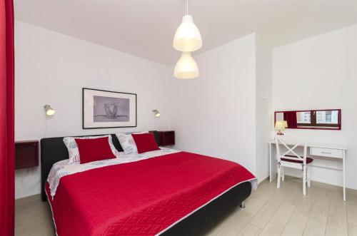 een slaapkamer met een rood bed en een bureau bij Apartment Mare in Srima