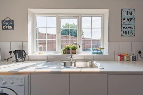 a kitchen with a sink and a window at St George's - stylish family home in Sandwich in Kent