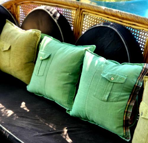 a couch with two green pillows on it at Homestay by the Tea Garden Dibrugarh in Dibrugarh