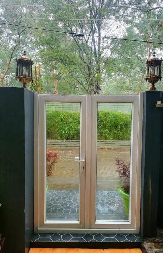a door with two windows and two lights at Homestay by the Tea Garden Dibrugarh in Dibrugarh