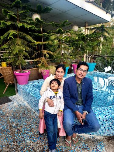 a family posing for a picture on a bench at Homestay by the Tea Garden Dibrugarh in Dibrugarh
