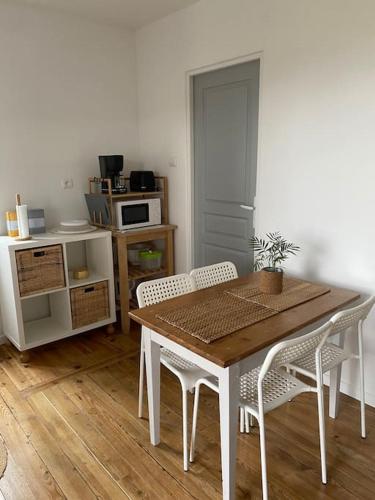 a dining room with a table and chairs and a kitchen at Studio dans ferme en rénovation in Touille
