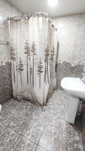 a bathroom with a shower curtain with a toilet and a sink at EleGaya Guest house in Ijevan