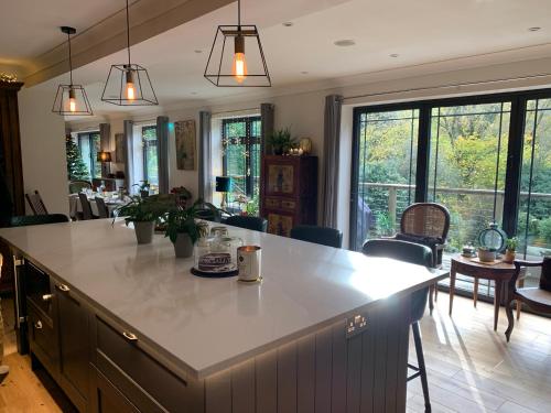 a kitchen and living room with a large white counter top at Stunning Surrey Hills Country House set in half an acre in Hindhead