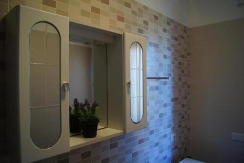 un bagno con specchio e piastrelle blu sul muro di Le Dune per 4 - Appartamento con piscina a Silvi Paese