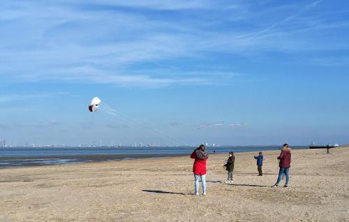 a group of people flying a kite on the beach at Kustverhuur, Vakantiepark Fort Soleil 43 in Breskens