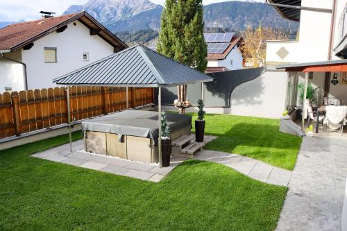 un cenador en el patio de una casa en Ferienwohnung am Waldweg en Kolsass