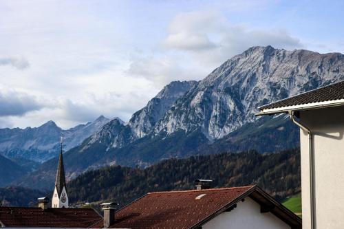 a view of a mountain range with a church at Ferienwohnung am Waldweg in Kolsass