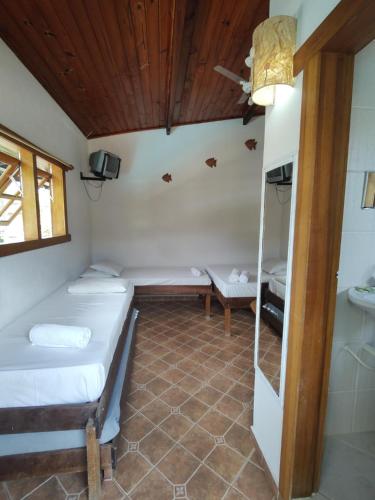 a room with two beds and a window at Brisa Maresias in Maresias