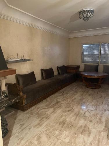 uma sala de estar com um sofá e uma mesa em Résidence les champs N3 em Casablanca