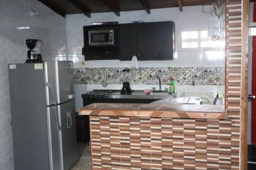 cocina con nevera, fregadero y microondas en Aparta Suite Torre De Prado 503, en Medellín