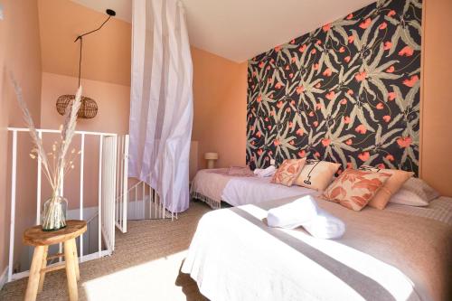 een slaapkamer met 2 bedden en een bloemenmuur bij La cabanette du sunset 5 *100m de la mer* in Guidel