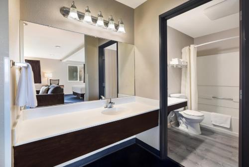 a bathroom with a sink and a toilet and a mirror at Americas Best Value Inn Sparks in Sparks