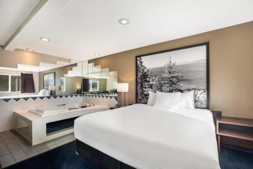 a hotel room with a large bed and a desk at Americas Best Value Inn Sparks in Sparks