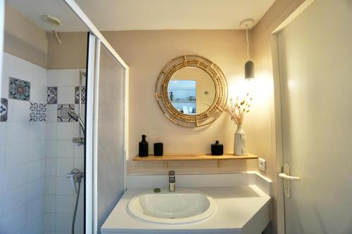 een badkamer met een wastafel en een spiegel bij La cabanette du sunset 5 *100m de la mer* in Guidel