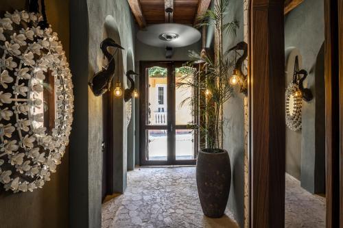 a hallway with a vase and a door with a plant at Privado Designer Boutique Hotel in Cartagena de Indias