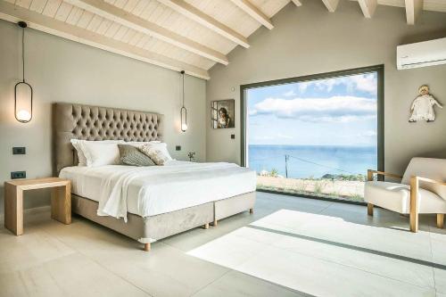 a bedroom with a large bed and a large window at Villa Iliotropos in Spathíon