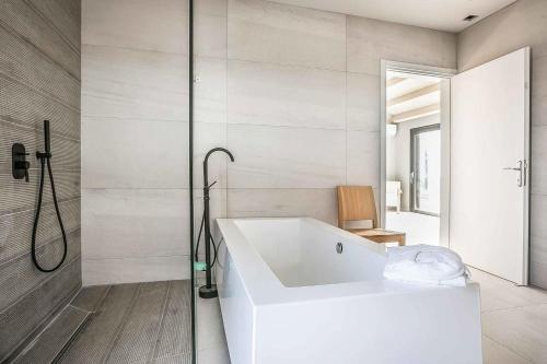 a white bath tub in a bathroom with a shower at Villa Iliotropos in Spathíon