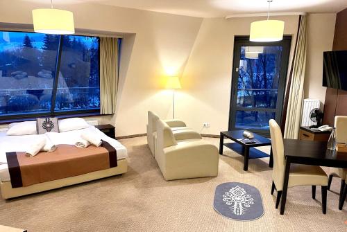 a hotel room with a bed and a desk and chair at Szklane Domy in Zakopane
